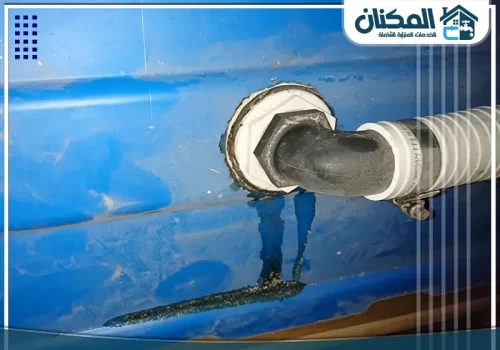معالجة تهريب الخزان الأرضي بمكة 0565367265 تسرب مياه حول وصلة خزان بلاستيكية متآكلة. تدل بقع الصدأ والرطوبة على الحاجة الماسة إلى صيانة خزانات محترفة