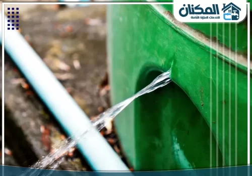 عزل الخزانات الخرسانية بمكة 0565367265 اندفاع مياه قوي من فتحة جانبية في خزان أخضر، مؤشراً على ضرورة صيانة خزانات عاجلة لوقف الهدر